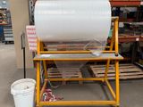 un gros rouleau de papier posé sur un chariot dans un entrepôt