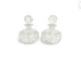 pair of clear glass perfume bottles on a white background