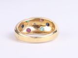 a close up of a gold ring with multi colored stones