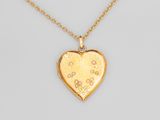 un collier avec un pendentif en forme de cœur en or, orné d'un petit motif floral
