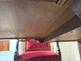 a red chair under a wooden table in a living room