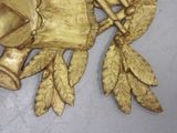 a gold plate with a bell and leaves on it