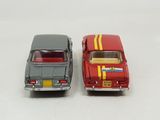 two toy cars sitting next to each other on a white surface