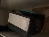 a printer sitting on top of a shelf in a room
