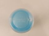 a small blue object on a white surface that appears to be a pill