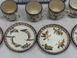many cups and saucers sitting on a table