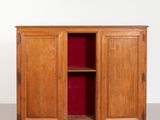 an old wooden cabinet with a red door and shelves