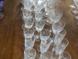 plusieurs verres posés sur une table en bois, avec un vase bleu en arrière-plan