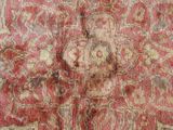 a close up of a red and white rug with a statue on it