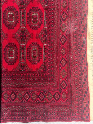 un tapis oriental orné d'un motif rouge et noir sur fond blanc