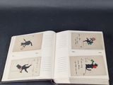 un livre ouvert sur lequel figurent des images de chats et d'oiseaux