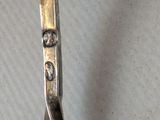 a silver spoon with a silver handle on a table