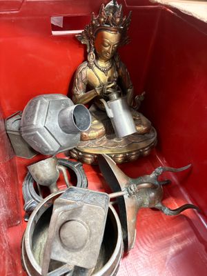 une boîte rouge sur laquelle figurent la statue d'une personne et un arrosoir