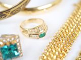 many different rings and bracelets on a white surface