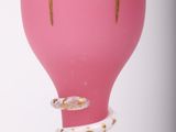 a pink vase that has a gold decoration on it