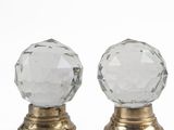 a pair of clear glass door knobs on gold bases