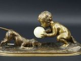 figurine en bronze représentant un garçon jouant avec un ballon en compagnie d'un chien