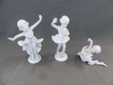 trois figurines représentant une jeune fille et deux cygnes posées sur une table