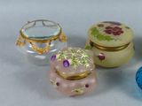 three small glass containers are sitting on a white surface