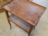 a small table with a shelf on it in the middle of a room