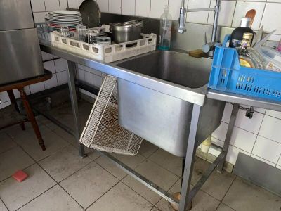 une cuisine équipée d'un évier et d'un plan de travail en métal