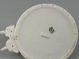 a close up of a white plate with a bird on it
