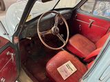 an old car with red leather seats and a steering wheel