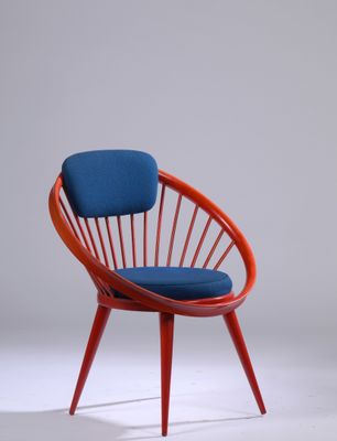 une chaise rouge avec un coussin bleu dessus