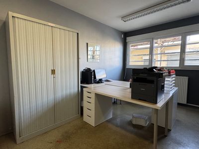 un bureau blanc sur lequel se trouve une imprimante, dans une pièce