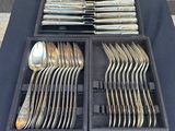 a lot of silver spoons and forks in a case