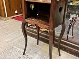 une petite table en bois avec une vitrine en arrière-plan