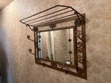 un miroir accroché au mur au-dessus d'un porte-serviettes