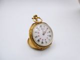 a small gold pocket watch with roman numerals on it