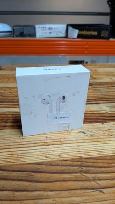 Des AirPods d'Apple sont posés sur une table en bois