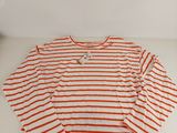 an orange and white striped shirt sitting on top of a white table