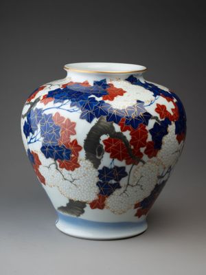 a vase with a design of flowers and leaves on it