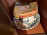 a stack of books sitting on a shelf next to a cup and saucer