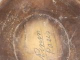 a brown vase with writing on it sitting on a table
