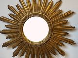 un miroir doré en forme d'étoile posé sur une table en bois