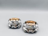 a pair of silver plated bowls with handles and handles