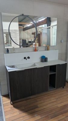 une salle de bains avec un lavabo et un miroir au mur