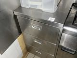une poubelle posée sur une armoire métallique dans une cuisine