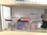a shelf with plastic containers and other items on it