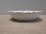 a white bowl sitting on a table with a wall in the background