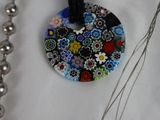 a necklace with a flower design on it and a red bead