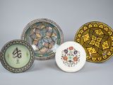 three plates with designs on them sitting next to each other