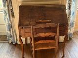 a small wooden desk with a chair in front of it