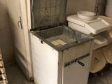 a small refrigerator in the corner of a dirty kitchen