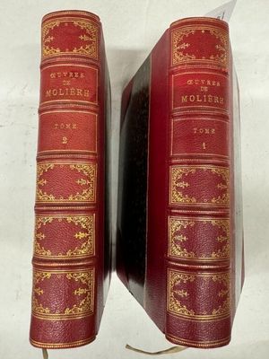 deux livres rouges posés l'un sur l'autre sur une surface blanche