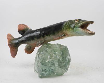 statue of a fish on a rock with its mouth open